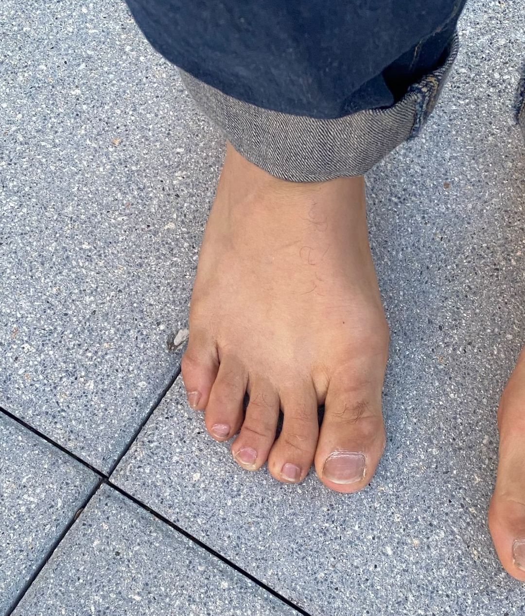 Gros plan d'un pied nu sur une dalle de granit